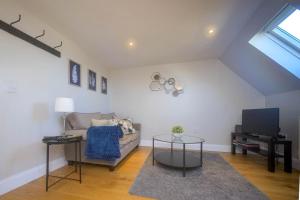 un soggiorno con divano e TV di Entire Apartment in Central Brockenhurst a Brockenhurst