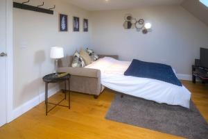 a bedroom with a bed and a couch and a table at Entire Apartment in Central Brockenhurst in Brockenhurst