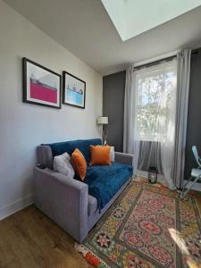 a living room with a blue couch and a window at Cosy and quiet one bedroom Thames flat in London