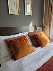 a bed with four pillows on it in a bedroom at Cosy and quiet one bedroom Thames flat in London