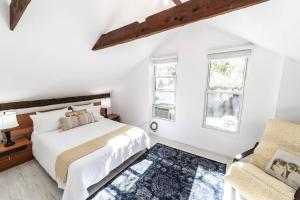 een witte slaapkamer met een bed en een stoel bij CreeksideHome, 2-5min to Ski,Hiking,Lake,Cafe&Bars in Windham