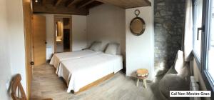 a bedroom with a white bed and a mirror at Cal Nen Mestre in Martinet