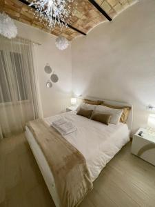 a bedroom with a large bed and a chandelier at Casa Vacanze - La Torre - Appartamento in Marta