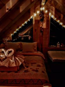 a bedroom in a log cabin with a bed and lights at Planinska kuća MESECEV PUT in Bajina Bašta