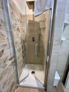 a shower with a glass door in a bathroom at Casa Vacanze - La Torre - Appartamento in Marta