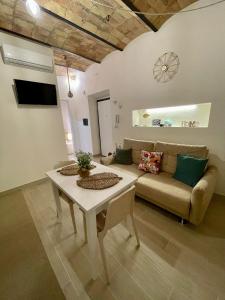 a living room with a couch and a table at Casa Vacanze - La Torre - Appartamento in Marta +6 photos