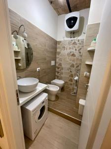 La salle de bains est pourvue de toilettes, d'un lavabo et d'un lave-linge. dans l'établissement Casa Vacanze - La Torre - Appartamento, à Marta