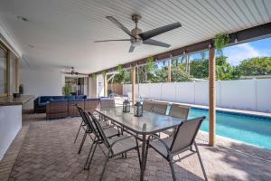 a patio with a table and chairs and a pool at Lauderdale By The Sea home in Fort Lauderdale