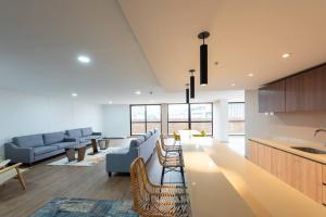 a kitchen and living room with a couch and chairs at 1305 Hermoso apartamento para estrenar in Bogotá
