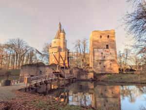 un antiguo castillo con un puente sobre un río en Hotel 1851, en Wijk bij Duurstede