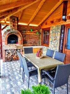 un patio con tavolo, sedie e forno in pietra di Planinska kuća MESECEV PUT a Bajina Bašta