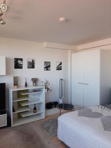 a white bedroom with a bed and a refrigerator at Appartement mit Penthaus Charakter in Fürth