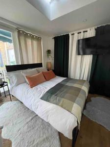 a bedroom with a large white bed with orange pillows at Cosy studio on the Thames in London
