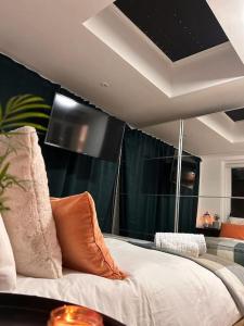 - une chambre avec un lit et une télévision murale dans l'établissement Cosy studio on the Thames, à Londres