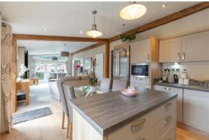 a kitchen with a large island in the middle of a room at Loubet Extra Large Lodge in Auchterarder