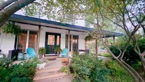 a house with two blue chairs on a porch at The River Farmhouse in Corbyville