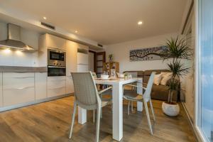 a kitchen and dining room with a table and chairs at Apartamento con terraza, vistas playa y montaña in Hospitalet de l'Infant