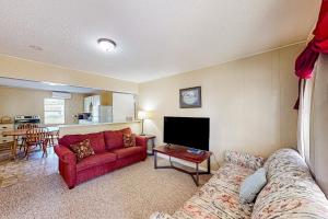 sala de estar con sofá rojo y TV en Bay Breeze, en Aransas Pass