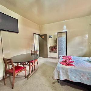 a room with a table and a table and a bed at Hotel Económico in Campo Grande +10 photos