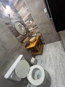 a bathroom with a toilet and a mirror and a table at CABAÑAS MECHI in Mar del Plata