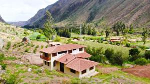 a house in a valley with mountains in the background at casa flores in Ollantaytambo