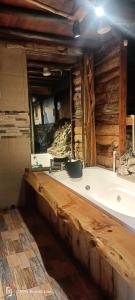 bañera en una cabaña de madera con espejo en Cabaña en el Arbol Picasso, en Bogotá