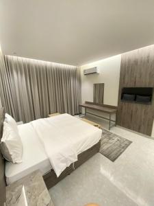 a bedroom with a white bed and a television at جده هاوس Jeddah house in Jeddah