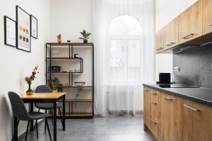 a kitchen with a table and a table and chairs at Stay2gether City Buzz Apt - O2 arena - Sleeps 6 in Prague