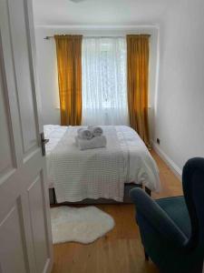 een slaapkamer met een bed met twee handdoeken erop bij Ealing Broadway bright flat in Ealing