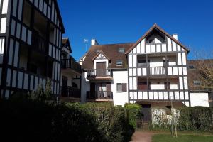 two white and black buildings next to each other at Studio Cabourg - Home-Varaville avec jardin in Varaville