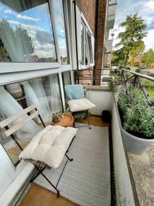 un balcón con 2 sillas y algunas plantas. en Ealing Broadway bright flat, en Ealing