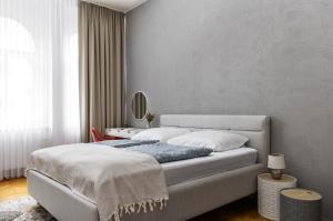 a bedroom with a large bed and a mirror at Stay2gether City Buzz Apt - O2 arena - Sleeps 6 in Prague