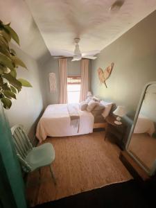 1 dormitorio con cama, silla y espejo en The River Farmhouse, en Corbyville