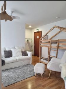 a living room with a white couch and a bunk bed at La Casina Del Alce in Aller