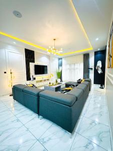 uma grande sala de estar com um sofá e uma televisão em Light Ville em Abuja