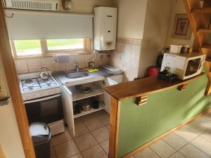 a small kitchen with a stove and a sink at La Barranca in Ushuaia