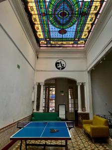 una camera con tavolo da ping pong e soffitto in vetro colorato di Hostel Bohemian House a Montevideo