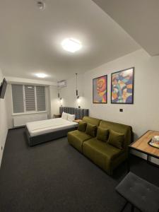uma sala de estar com uma cama e um sofá em VATRA HOTEL em Ternopil