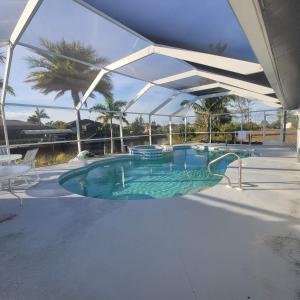 a large swimming pool with an umbrella over it at Sunsets by the Water in Cape Coral