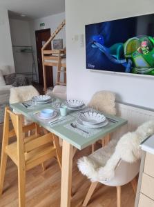 een tafel en stoelen in een woonkamer met een tv bij La Casina Del Alce in Aller