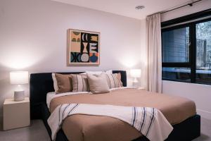 1 dormitorio con 1 cama con 2 lámparas y una ventana en Snow & Swing Getaway - Three Bedrooms with Hot Tub (Stay Revy) en Revelstoke