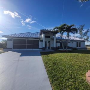 a white house with palm trees and a driveway at Sunsets by the Water in Cape Coral