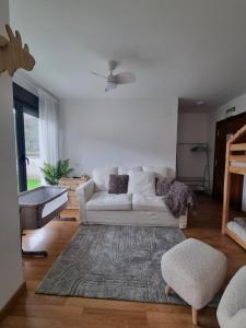 een woonkamer met een witte bank en een tapijt bij La Casina Del Alce in Aller