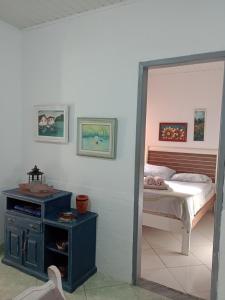 - une chambre dotée d'un lit et d'une table de chevet dans l'établissement Casa de Praia em São Pedro da Aldeia, à São Pedro da Aldeia