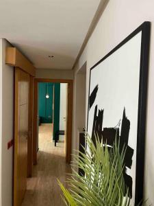 un couloir avec une peinture sur le mur et une plante dans l'établissement Luxurious 1bd room apartment in Agdal Rabat city, à Rabat