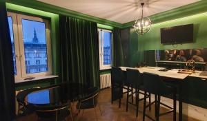 uma sala verde com uma mesa, cadeiras e janelas em City Center by Better Place em Varsóvia