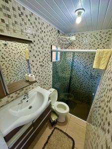 La salle de bains est pourvue d'un lavabo, de toilettes et d'une douche. dans l'établissement Casa Prainha Evandro, à Laguna