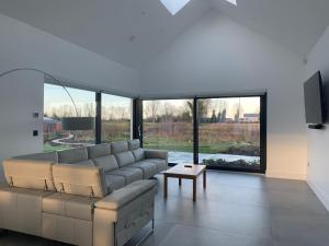 a living room with a couch and a large window at Red Sheds Villa Portarlington 