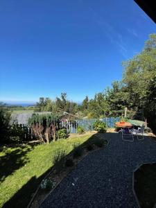 a garden with a table and chairs and a fence at Cabaña con vista al Lago in Ranco