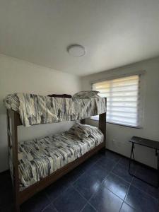 two bunk beds in a room with a window at Cabaña con vista al Lago in Ranco